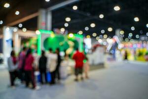 Blurred images of trade fairs in the big hall. image of people walking on a trade fair exhibition or expo where business people show innovation activity and present products in a big hall. photo