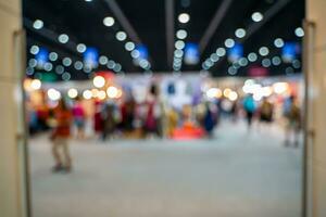 Blurred images of trade fairs in the big hall. image of people walking on a trade fair exhibition or expo where business people show innovation activity and present products in a big hall. photo