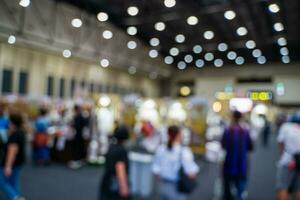 Blurred images of trade fairs in the big hall. image of people walking on a trade fair exhibition or expo where business people show innovation activity and present products in a big hall. photo