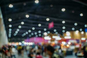 Blurred images of trade fairs in the big hall. image of people walking on a trade fair exhibition or expo where business people show innovation activity and present products in a big hall. photo