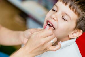 Cute preschool child is engaged in speech therapist office and correcting his speech photo