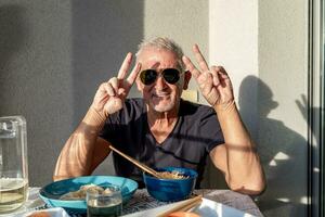 attractive middle-aged man have fun while eating sitting at a table laid  Chinese take away food photo