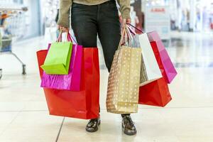 woman is showing colorful shopping bags at the mall photo