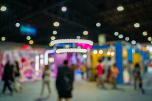 Blurred images of trade fairs in the big hall. image of people walking on a trade fair exhibition or expo where business people show innovation activity and present products in a big hall. photo