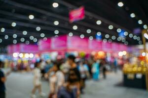 Blurred images of trade fairs in the big hall. image of people walking on a trade fair exhibition or expo where business people show innovation activity and present products in a big hall. photo