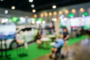 Blurred images of trade fairs in the big hall. image of people walking on a trade fair exhibition or expo where business people show innovation activity and present products in a big hall. photo