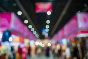 Blurred images of trade fairs in the big hall. image of people walking on a trade fair exhibition or expo where business people show innovation activity and present products in a big hall. photo