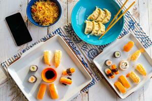 top view of various Chinese foods in the colorful bowls on a wooden table photo