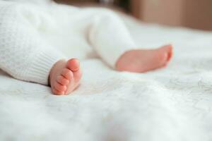 Bare baby feet on the bed close-up photo