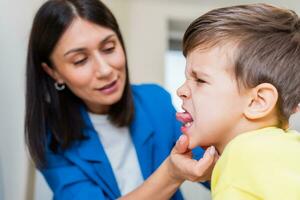 A woman speech therapist deals with the child and teaches him the correct pronunciation and competent speech. photo