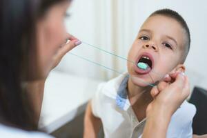 A woman speech therapist deals with the child and teaches him the correct pronunciation and competent speech. photo