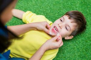 Woman speech therapist helps a child correct the violation of his speech in her office photo