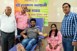 Delhi, India, July 19 2023 - Blood donor at Blood donation camp held at Balaji Temple, Vivek Vihar, Delhi, India, Image for World blood donor day on June 14 every year, Blood Donation Camp at Temple photo