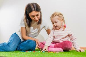 Woman speech therapist teaches a girl the correct pronunciation and literate speech photo