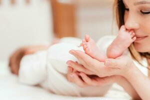 Mother hugs legs of newborn baby with hands photo