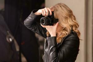 Portrait of a cute girl photographer taking pictures in a photo studio