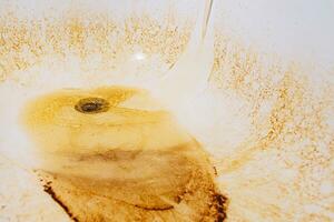 Rusty water flows from the tap into the bathtub photo