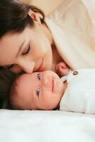 hermosa madre besos su pequeño bebé hija foto