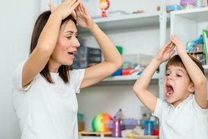 Beautiful woman speech therapist teaches boy the correct pronunciation of words and sounds in the office photo