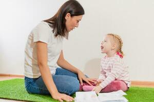 Woman speech therapist helps girls correct her speech photo