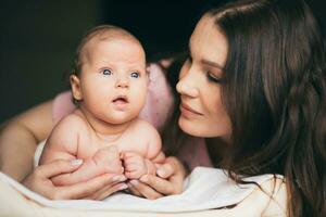 Portrait of a young woman who tenderly cares for her baby photo