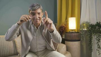 vecchio uomo guardare a telecamera con ingrandimento bicchiere. video