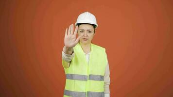 The engineer looks at the camera and makes a stop sign. video