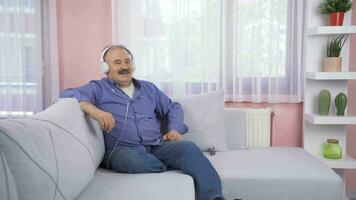 sobredosis hombre mirando fuera el ventana y escuchando a música con auriculares. video