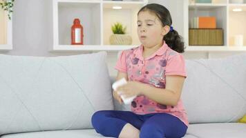 Girl child covering his mouth and nose with a tissue while coughing. video