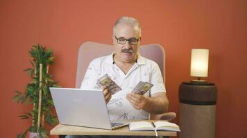 Man looking at laptop counting money. video