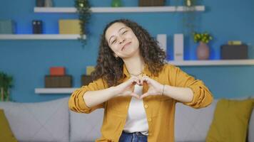 jovem mulher fazer coração placa às Câmera. video