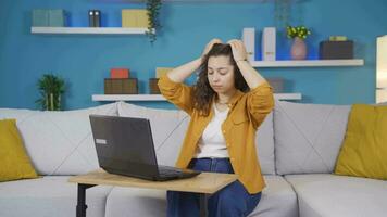 Young woman working on laptop has a headache. video