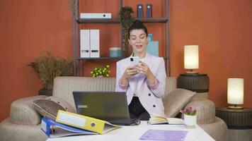 Woman working from home enjoys mobile apps on phone. video