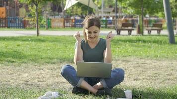 The woman applauds what he sees on the laptop. video