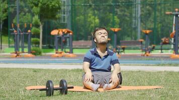 enano joven hombre haciendo Deportes al aire libre es pensativo y en un trance. video