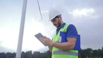 técnico ingeniero trabajando en viento turbina o operador control S viento utilizando tableta. video