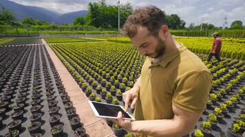 Young agricultural engineer works in greenhouse. video