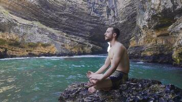 Muscular and attractive young man meditating. video