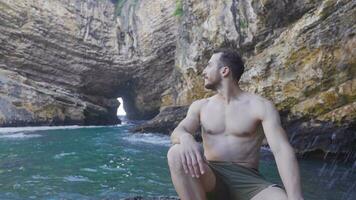 Young man on the shore of the wavy sea. video