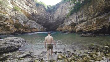 Swimming in the sea bay. Young man entering the sea. video