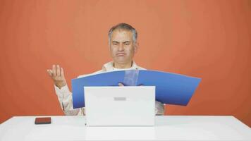 Man working on laptop throws files angrily. video