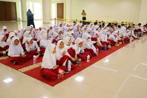 Bogor, Indonesia, 2023 - Elementary school boys and girls sitting watching the teacher photo