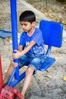 asiático chico haciendo rutina ejercicio en sociedad parque durante el Mañana tiempo. linda pequeño niño ejercicio y gimnasio a mantener él mismo ajuste para vida. niño ejercicio al aire libre disparar foto