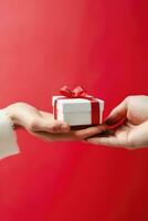 Close up shot of female hands holding a small gift wrapped with red ribbon. AI Generated photo