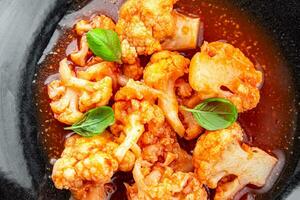 cauliflower in tomato sauce stewed vegetable second course healthy eating appetizer meal food snack on the table copy space food background rustic top view keto or paleo diet vegetarian vegan photo