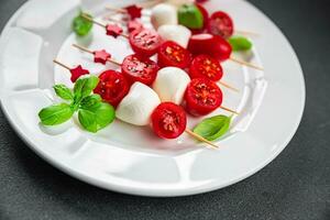 Caprese canapes mozzarella and tomato appetizer salad on a skewer finger food delicious healthy eating cooking appetizer meal food snack on the table copy space food background rustic top view photo