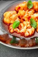 cauliflower in tomato sauce stewed vegetable second course healthy eating appetizer meal food snack on the table copy space food background rustic top view keto or paleo diet vegetarian vegan photo