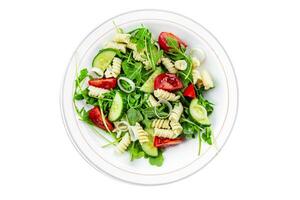 pasta salad fusilli pasta, cucumber, tomato, green lettuce, onion eating appetizer meal food snack on the table copy space food background rustic top view photo