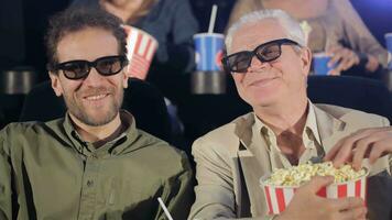 Two men watching 3D film at the movie theater video