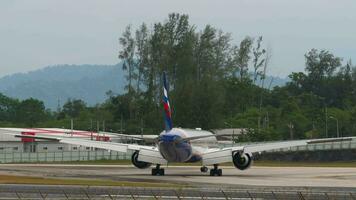 phuket, Tailândia janeiro 29, 2023 corpo largo aeronave boeing 777 do aeroflot taxiando às phuket aeroporto, lado visualizar. passageiro transportadora em a taxiway. aeródromo em uma tropical ilha video